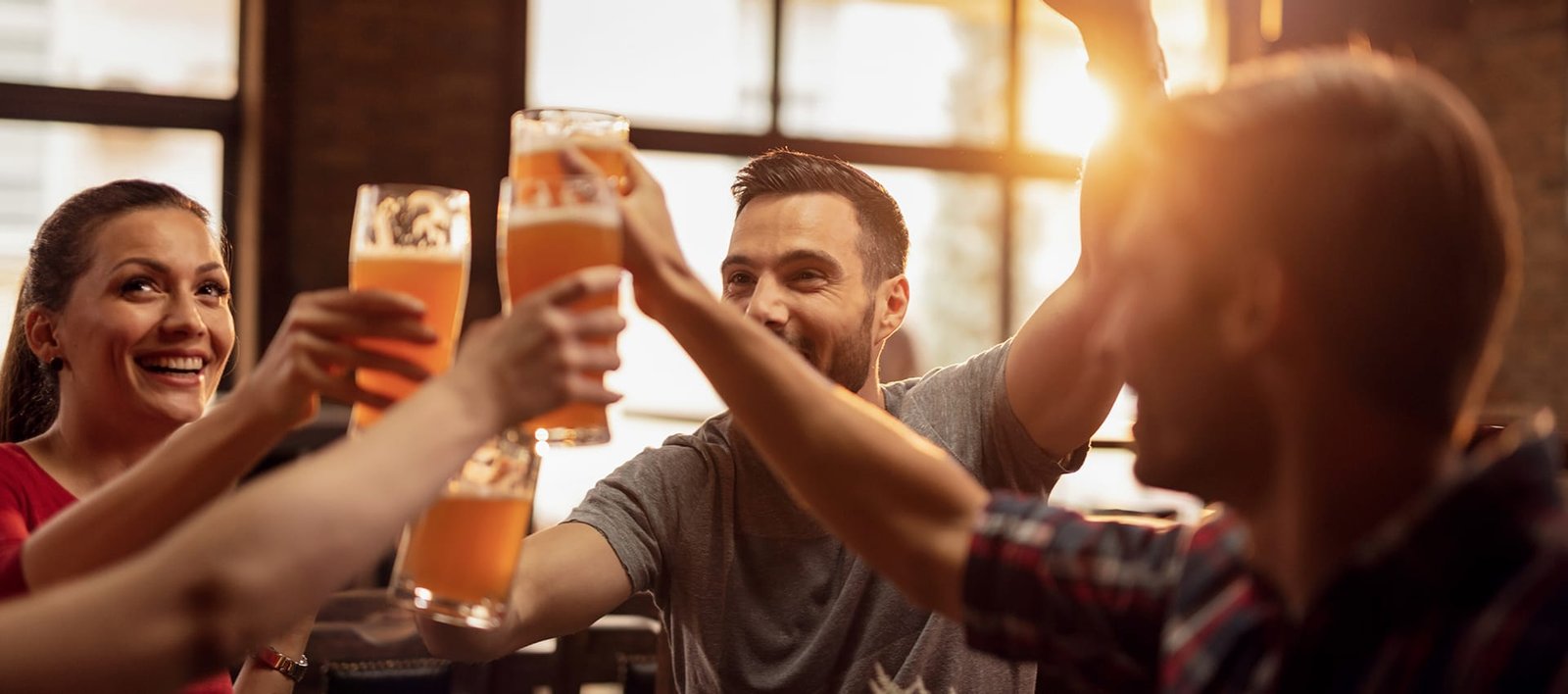 grupo-jovenes-felices-brindando-cerveza-divirtiendose-pub